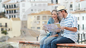 Happy couple of tourists checking map and contemplating views