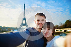 Happy couple of tourists taking selfie in Paris