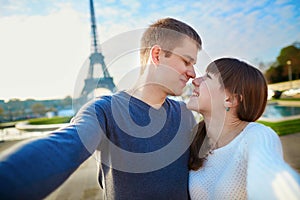 Happy couple of tourists taking selfie in Paris