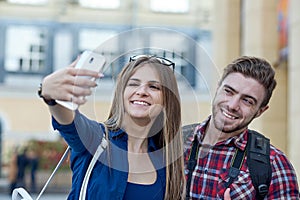 Happy couple of tourists taking selfie in showplace of city