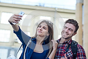 Happy couple of tourists taking selfie in showplace of city