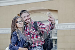 Happy couple of tourists taking selfie in showplace of city