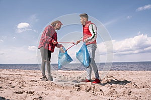 happy couple with trash bags and