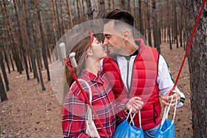 happy couple with trash bags holding