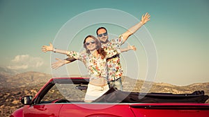 Happy couple travel by car in the mountains