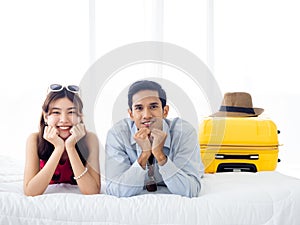Happy couple travelers on honeymoon trip. Asian man in denim shirt and young beautiful woman smile and lying together.