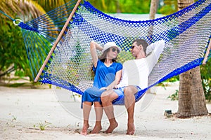 Happy couple on tropical vacation relaxing in hammock