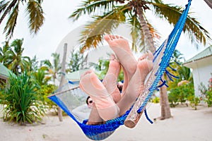 Happy couple on tropical vacation relaxing in hammock