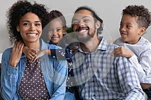 Happy couple with two funny adorable kids having fun together