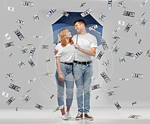 Happy couple with umbrella standing money rain