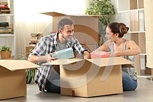 Happy couple unboxing belongings moving house photo