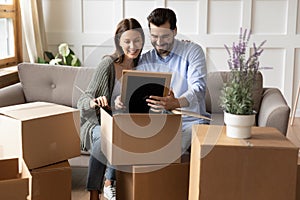 Happy couple unpack boxes settling at new home