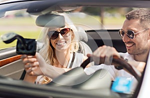 Happy couple usin gps navigation system in car