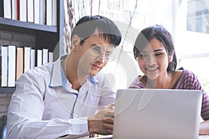 Happy Couple using computer working together at home