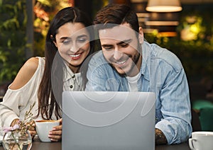 Happy Couple Using Laptop Having Date Enjoying Coffee In Cafe