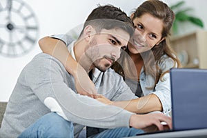 Happy couple using laptop at home photo