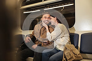 Happy couple using mobile phone in train. Public transport