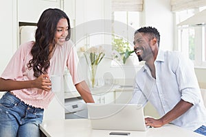 Happy couple using their laptop at breakfast