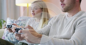 Happy couple, video games and playing on sofa in living room for fun entertainment together at home. Man and woman smile