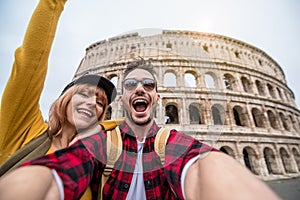 Happy couple visiting Colosseum in Rome, Italy - Young Friends takes selfie at Coliseum