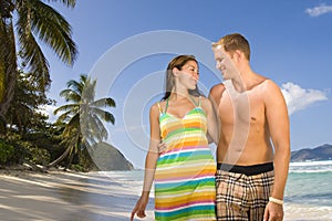 Happy couple walking along a tropical beach