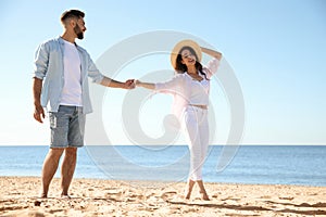 Happy couple walking on beach near sea. Honeymoon trip