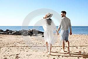 Happy couple walking on beach near sea. Honeymoon trip
