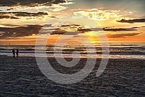 Happy couple walking on the beach at sunrise for holiday time