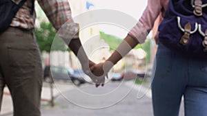 Happy couple walking in city holding hands, travelling together, outdoor date