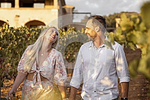 Happy couple walking through a mediterranean vineyard