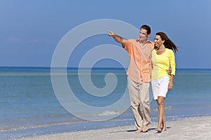 Happy Couple Walking and Pointing on A Beach