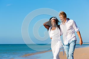 Happy couple walking and running on beach