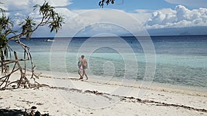 Happy couple walking on a tropical beach