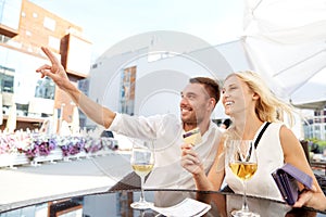 Happy couple with wallet paying bill at restaurant