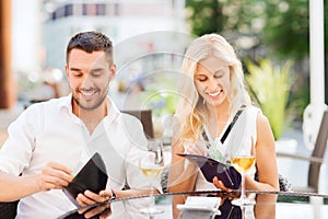 Happy couple with wallet paying bill at restaurant photo