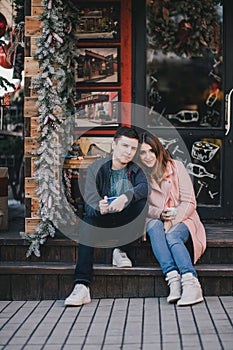 Happy couple in warm clothes drinking coffee on a Christmas market