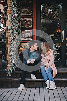 Happy couple in warm clothes drinking coffee on a Christmas market