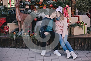 Happy couple in warm clothes posing on a Christmas market