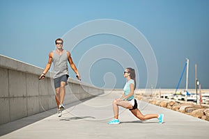 Happy couple warming up on pier before training