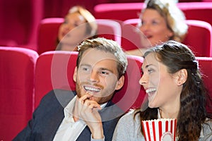 Happy couple watching movie in cinema