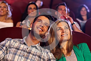 Happy couple watching movie in cinema