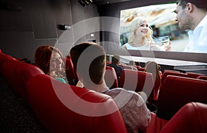 Happy couple watching movie and talking in theater