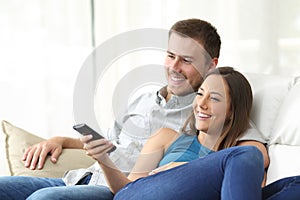 Happy couple watching tv at home photo