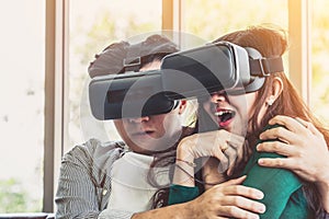 Happy couple watching video in virtual reality VR