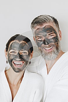 Happy couple wearing a charcoal mask