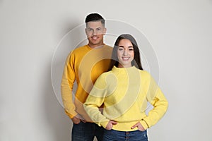 Happy couple wearing yellow warm sweaters on white background