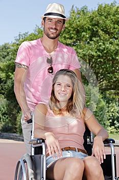 Happy couple in wheelchair having fun in park