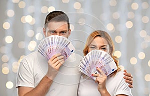 Happy couple in white t-shirts with euro money