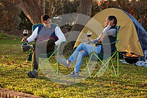 Happy, couple and wine by camping in outdoor to celebrate anniversary with love or bonding together. Smile, man and