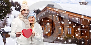 Happy couple in winter clothes with heart outdoors